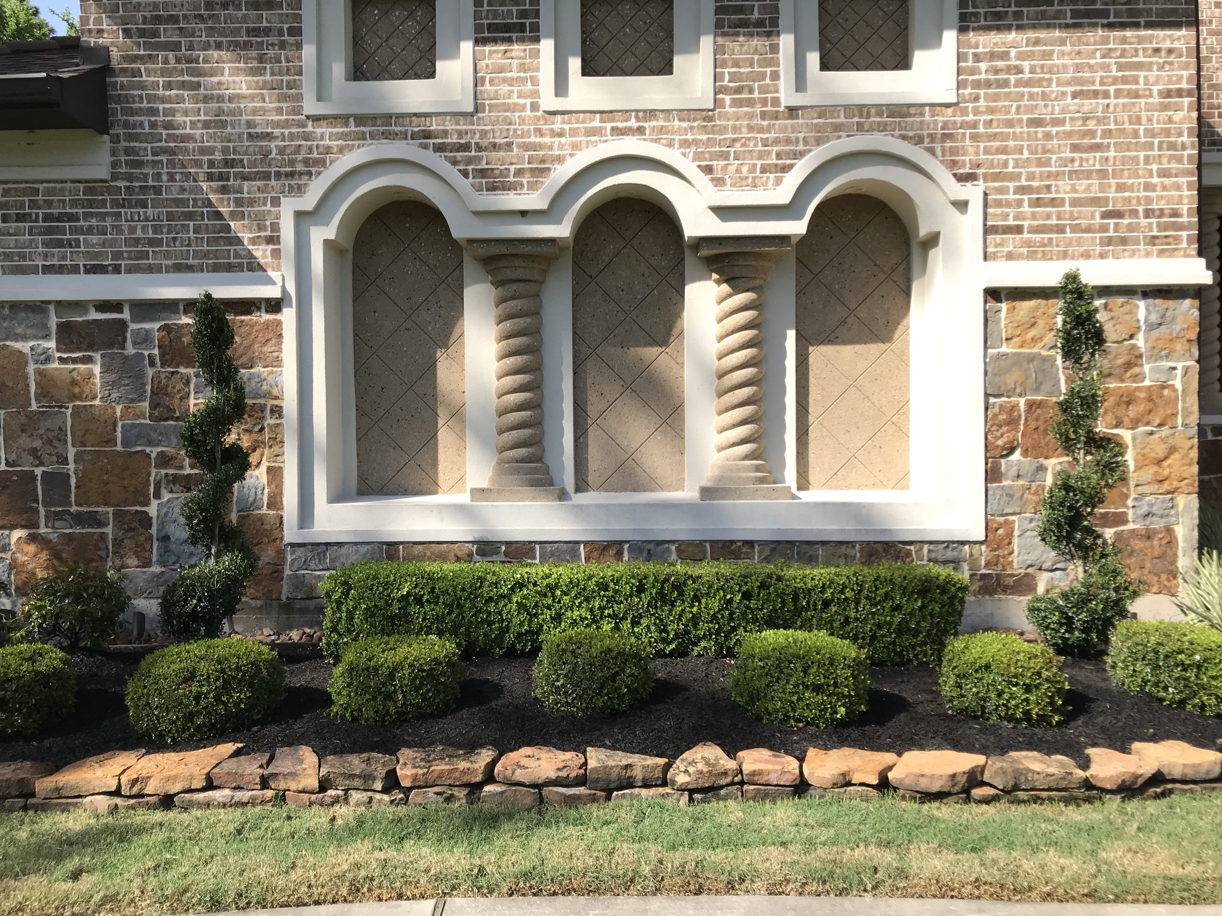Houston brick home with boxwoods, stone border, and finished front beds