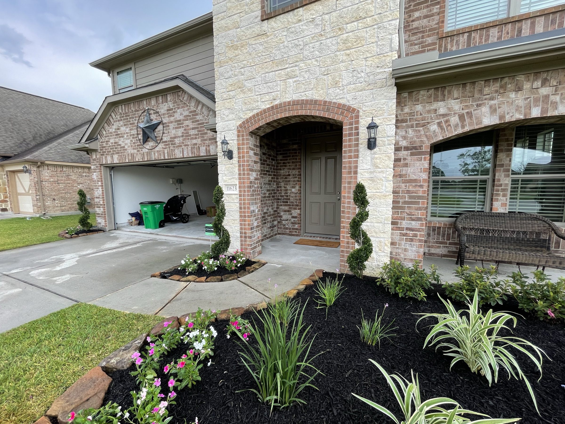 New Houston entry beds with seasonal color and spiral topiary