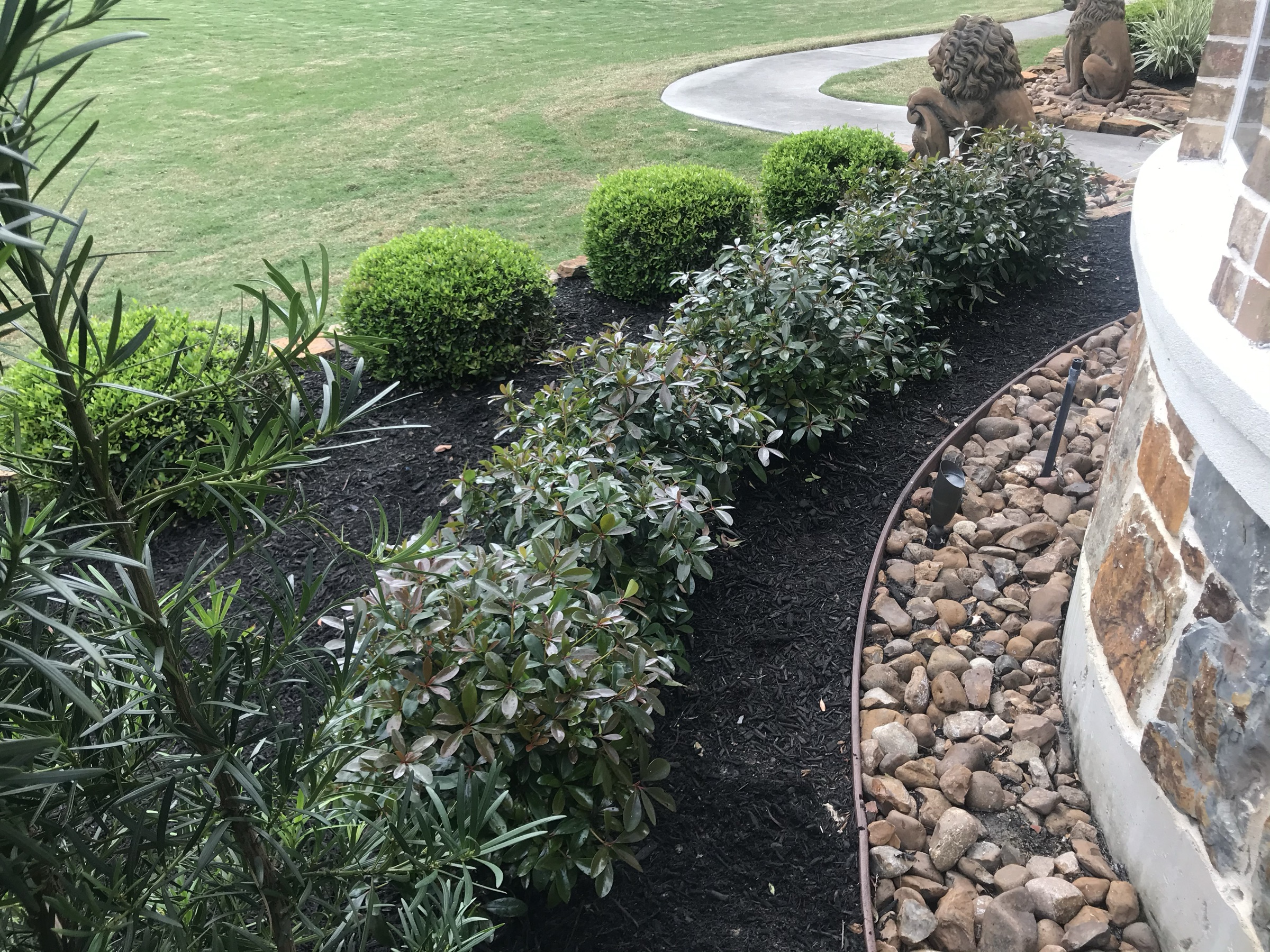 Planted Houston beds with mulch, stone edge, and path lights
