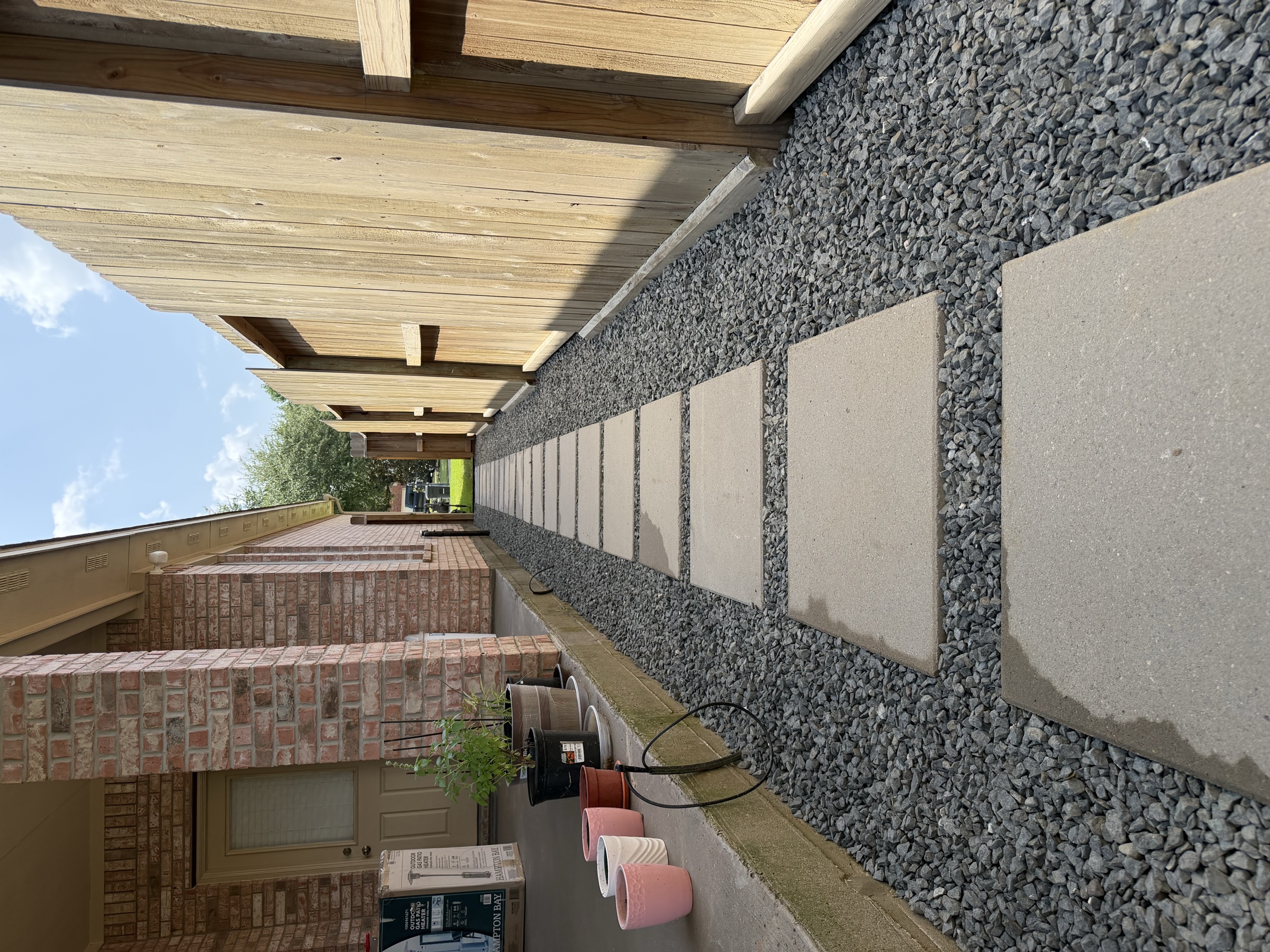 Concrete stepping stones in gravel along a Houston side yard