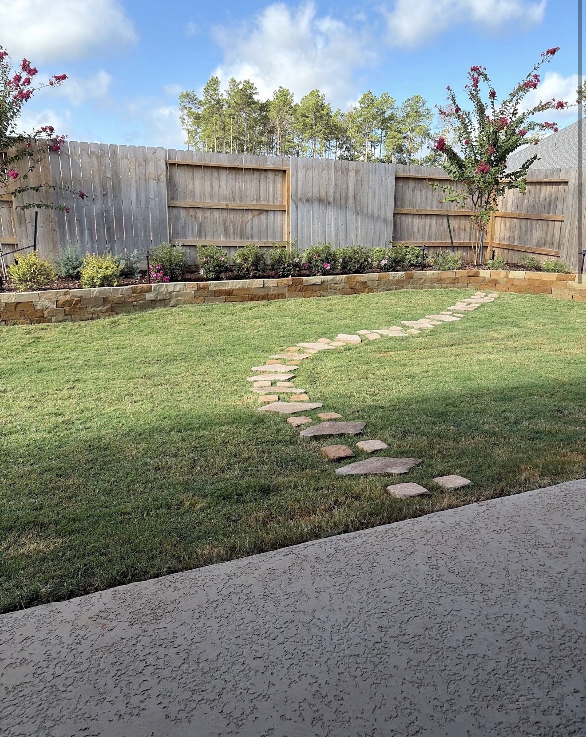 Limestone retaining wall and stepping-stone path on a Houston backyard