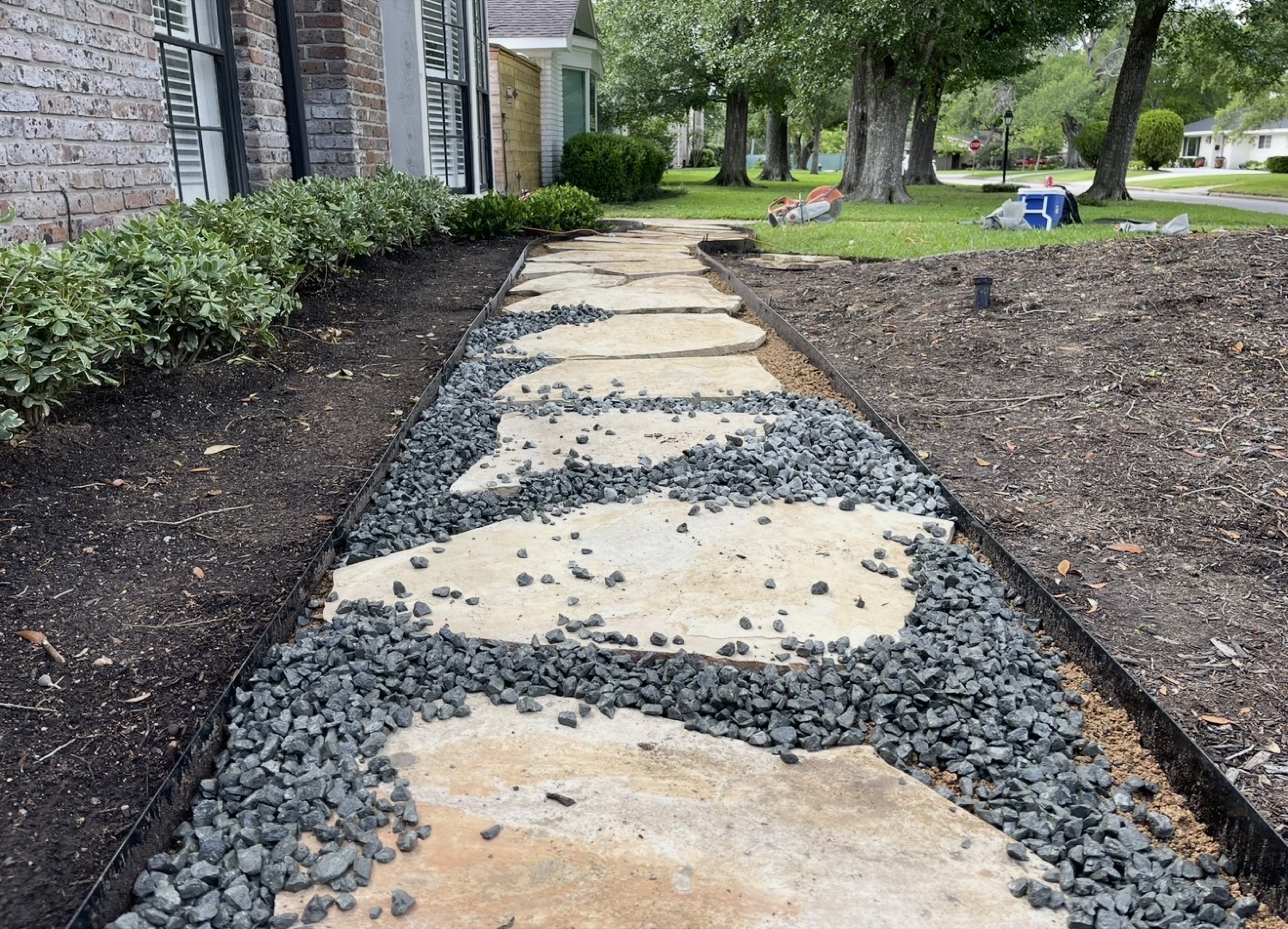 Flagstone stepping walk with gravel along a Houston home