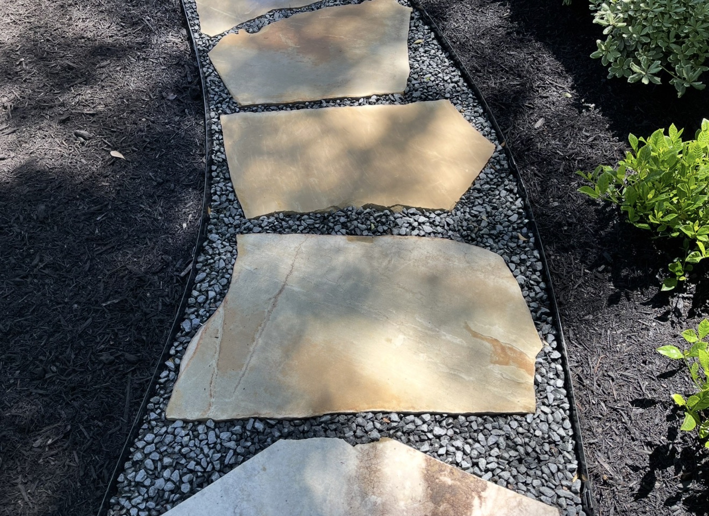 Irregular flagstone stepping stones in gravel