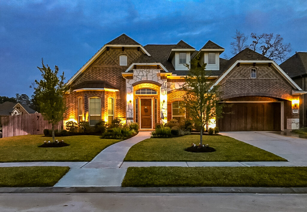 Modern residential home in Tomball, featuring well-maintained landscaping, outdoor lighting, and a welcoming entrance, showcasing Danny's Landscaping expertise in enhancing curb appeal.